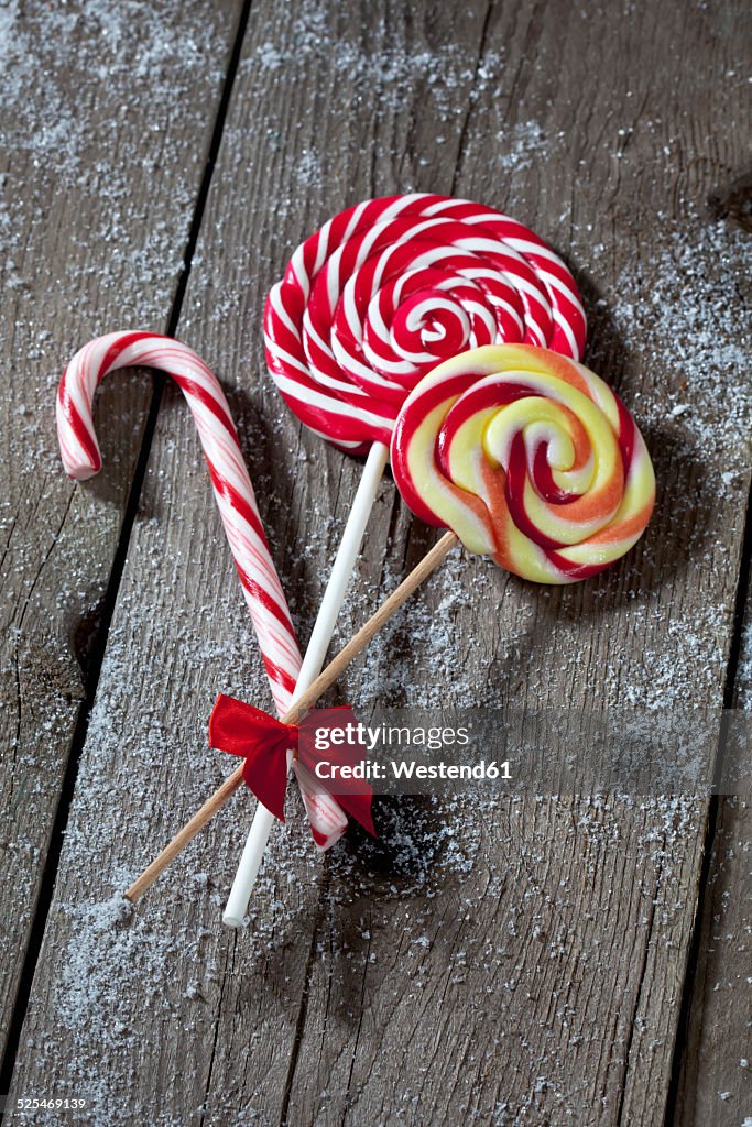 Two lollies and a sugar cane on grey wood