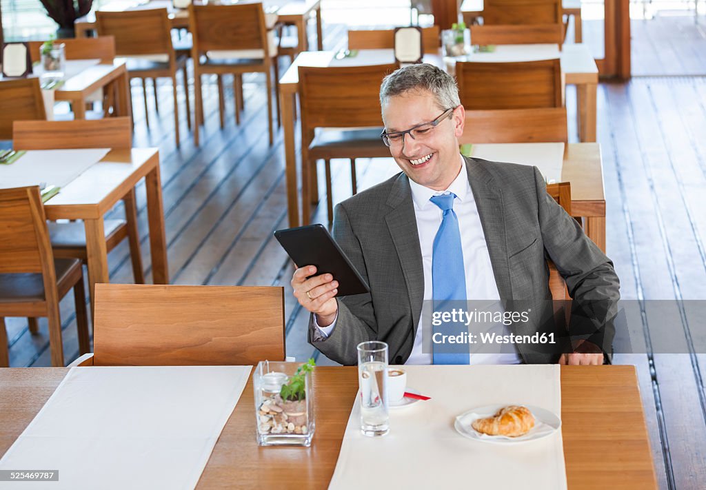 Businessman in restaurant with digital tablet