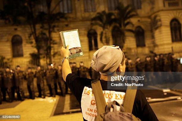 Teacher shows a book to riot police in front the State's Department of Education during a protest of the teacher of the State of Sao Paulo, that are...