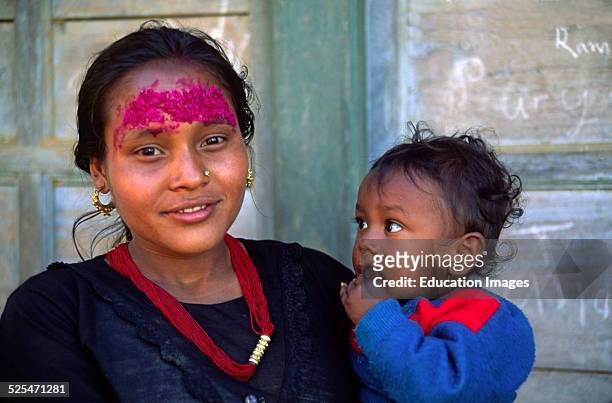 Giant Rice Tika Beautifies This Young Mother With Child In Khandbari On Route To Makalu, Nepal.