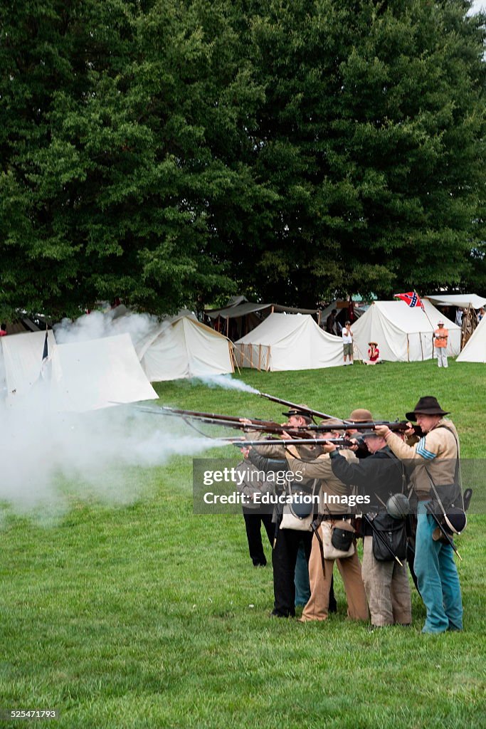 Squad of men in Confederate uniforms fire their rifles in Civil War reenactment, Manassas, Virginia