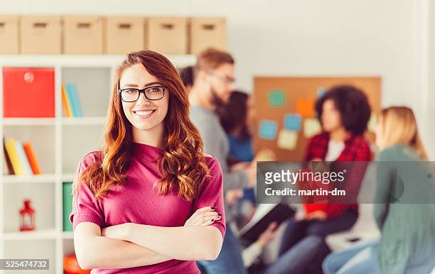 college student with crossed arms looking at camera - beautiful college girls stock pictures, royalty-free photos & images