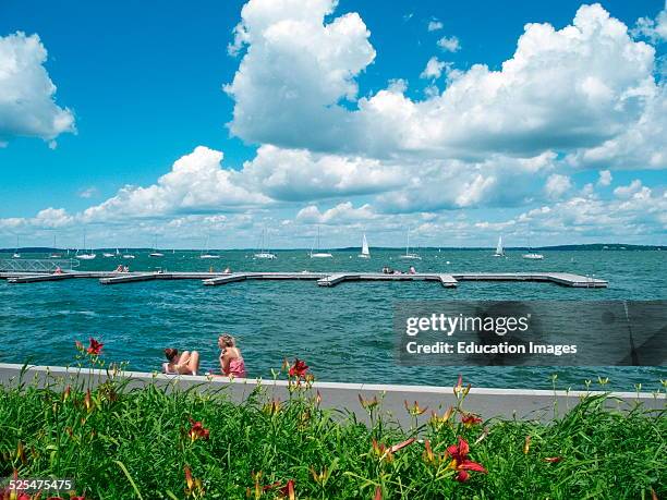 Two women relax by lake at University of Wisconsin, Madison, Wisconsin.