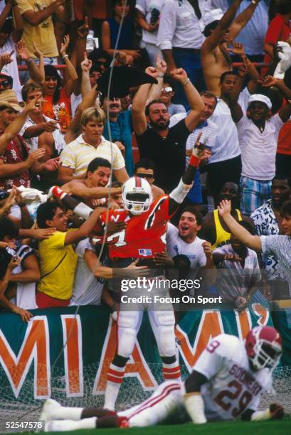 Miami Hurricanes' Michael Irvin joins the crowd in celebration after scoring a touchdown.