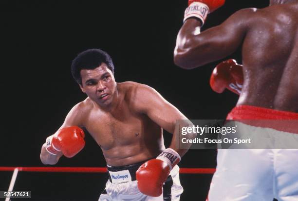 Muhammad Ali takes aim at his opponent during a boxing match.