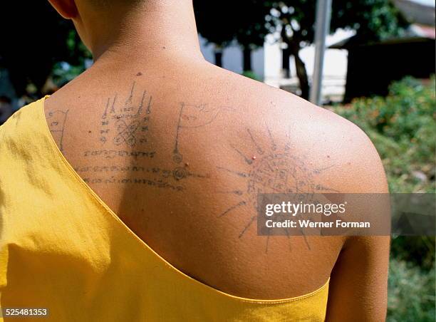 Buddhist monk with 'wheel of life' tattoo on his back, Thailand, 1977.