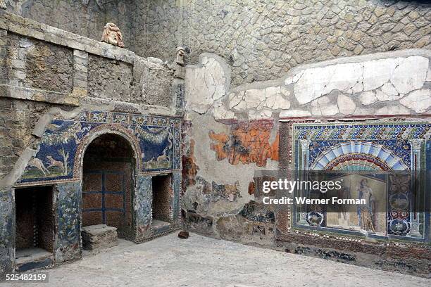 Herculaneum. House of the Mosaic of Neptune and Amphitrite. A small courtyard forming an open-air dining room. One wall is decorated with a mosaic...