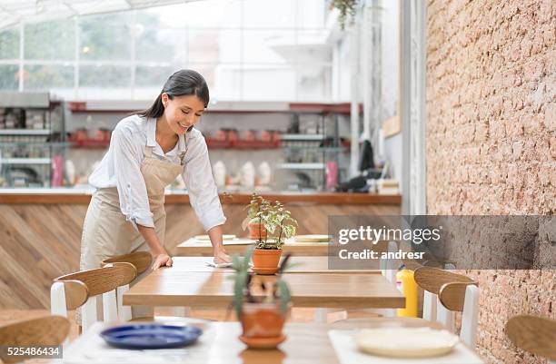 waitress setting a table at a restaurant - restaurant cleaning stock pictures, royalty-free photos & images