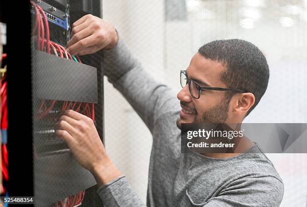 it technician fixing a server at the office - cable modems stock pictures, royalty-free photos & images