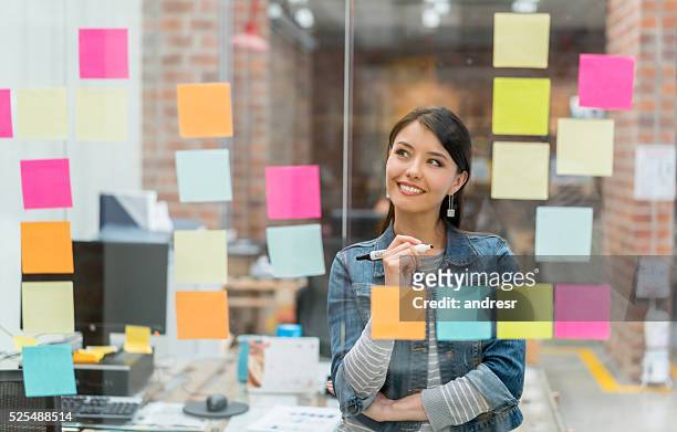 donna che pensa alle idee in ufficio - ispirazione foto e immagini stock