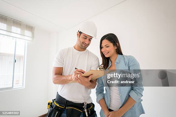 contractor talking to a woman at home - home improvement contractor stock pictures, royalty-free photos & images