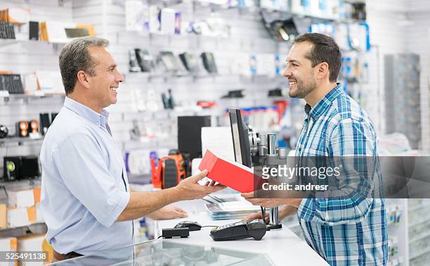 uomo che fa shopping in un negozio di tecnologia - negozio di elettrodomestici foto e immagini stock