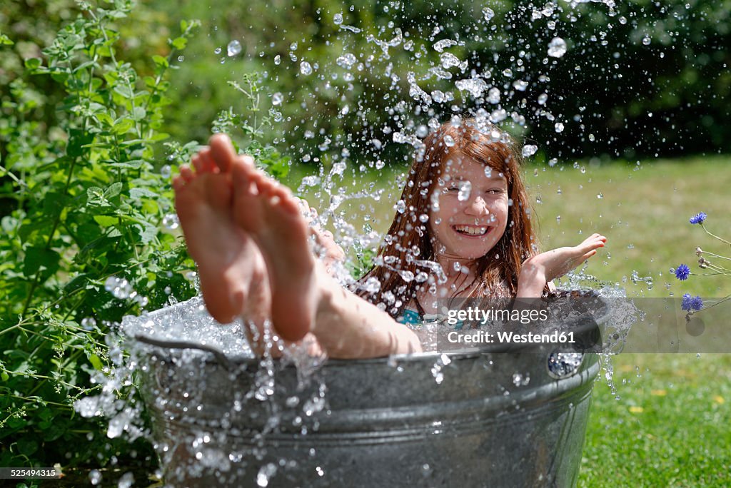 Girl splashing in a zinc tub