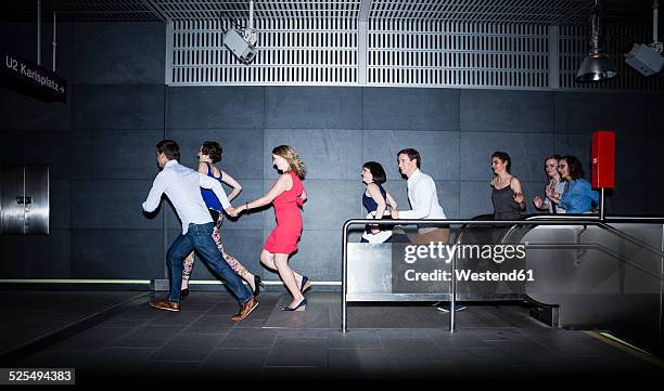 group of friends running in subway station - running up an escalator stock pictures, royalty-free photos & images