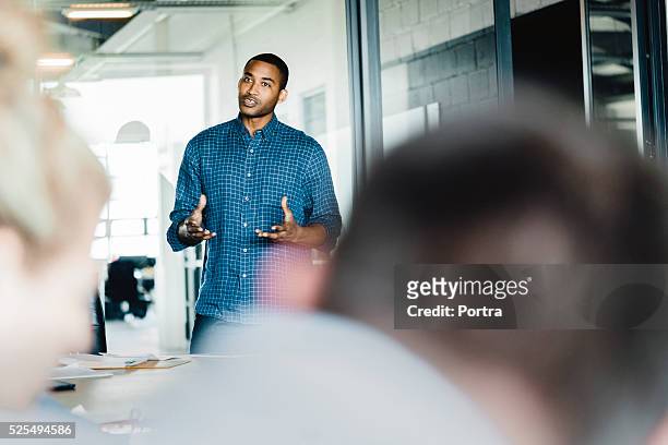 young businessman giving presentation in office - kleine scherptediepte stockfoto's en -beelden