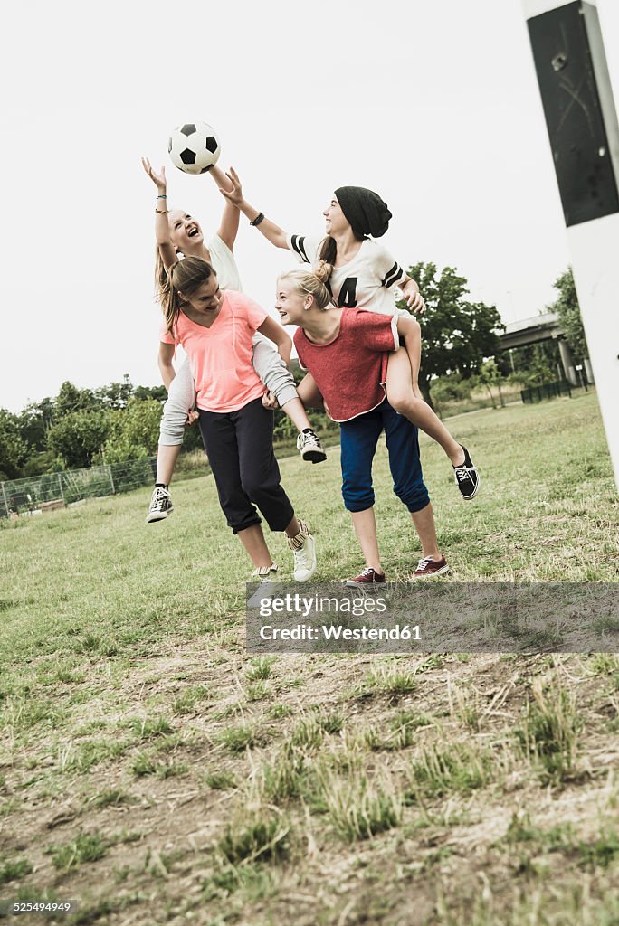 Four teenage girls having fun on a soccer field