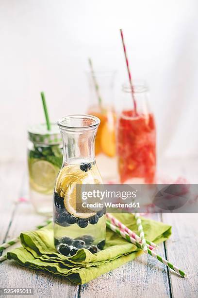 carafes of miscellaneous fruit infused water on cloth and wood - blackberry fruit pattern stock pictures, royalty-free photos & images