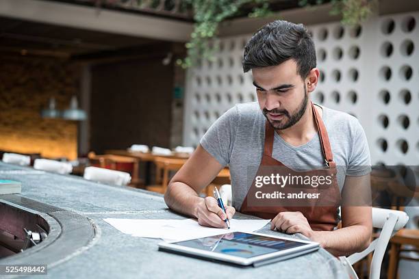 business man doing the books at a restaurant - restaurant owner stockfoto's en -beelden