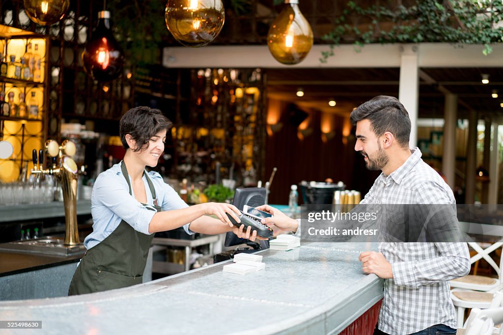 Homme payant par carte dans un restaurant