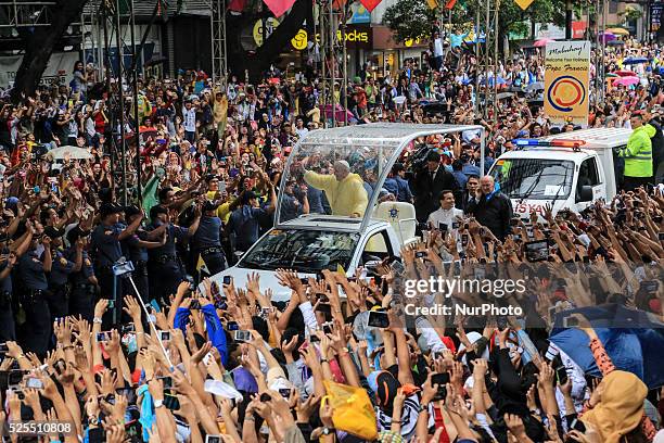 Pope Francis waves to the crowd after conducting mass in Manila on January 18, 201. Pope Francis is visiting venues across Leyte and Manila during...