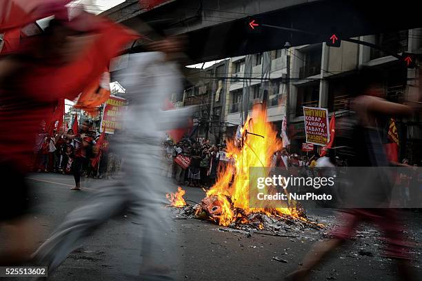 Protesters dance around a burning effigy depicting President Aquino during a demonstration outside the presidential palace in Manila, Philippines,...