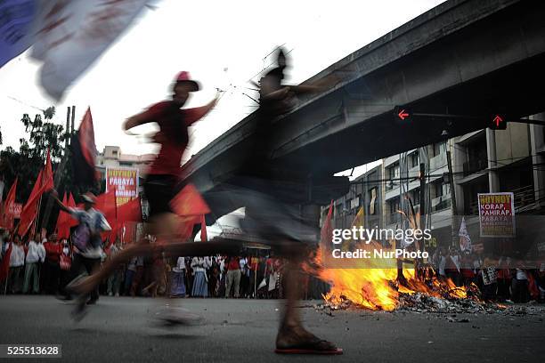 Protesters dance around a burning effigy depicting President Aquino during a demonstration outside the presidential palace in Manila, Philippines,...