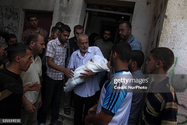 Relative of the wife of Hamas's military leader, Mohammed Deif, and his infant son Ali, whom medics said were killed in Israeli air strikes, carries...