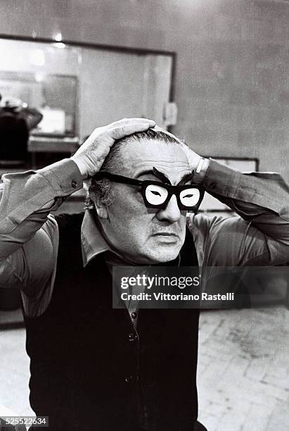 Italian movie director Federico Fellini wearing a pair of comic spectacles.