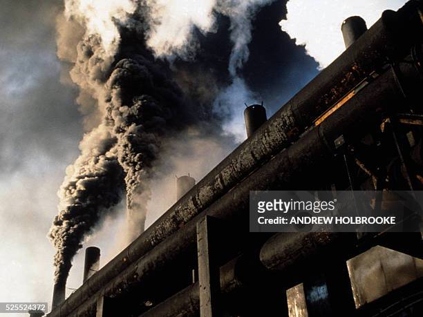 Smoke pours out of a factory in Copsa Mica, Romania. The billowing, carcinogenic black clouds of carbon black, used for dyes and tires, pollutes and...