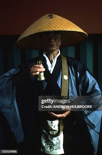 Buddhist monk begs for alms, for his pagoda, on the streets of Kyoto.