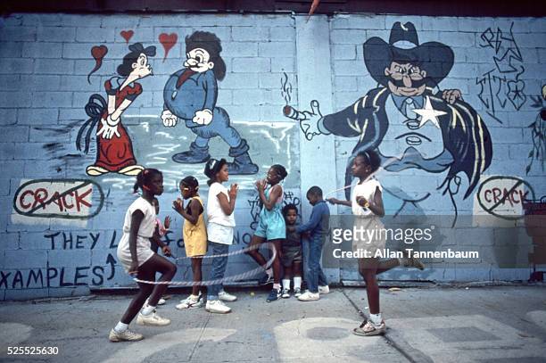 Kids play in front of a wall with anti-drug graffiti, New York, New York, September 14, 1986.