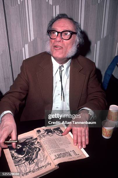 Science Fiction author Isaac Asimov at a Science Fiction convention autographs a vintage copy of 'I, Robot,' New York, New York, March 28, 1982.