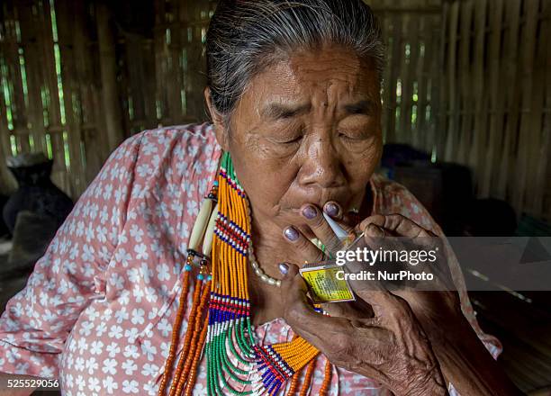 An Indian Nocte tribe woman smokes home made cigarette, locally known as Beedi at Noga village, Naharkatia in the northeastern state of Assam on the...