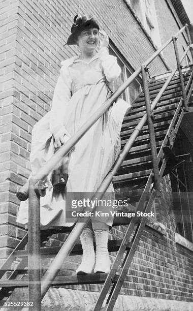 Young woman poses on a metal stair on her way down.