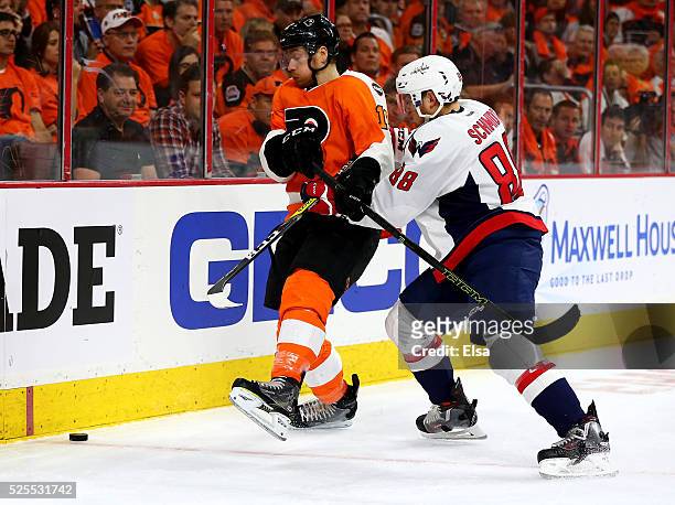 Michael Raffl of the Philadelphia Flyers and Nate Schmidt of the Washington Capitals fight for the puck in Game Three of the Eastern Conference First...