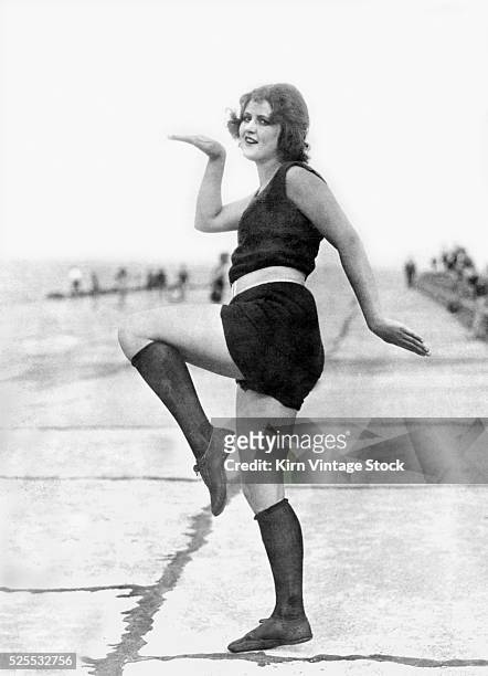 Swimming suit clad flapper strikes a pose on the breakwater, ca. 1925.
