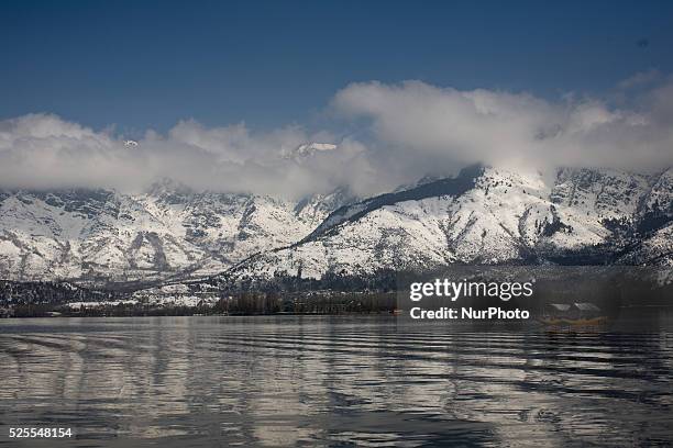 Snow capped Zabarvan mountains are reflected in Dal lake on March 10, 2015 in Srinagar, the summer capital of Indian administered Kashmir, India....