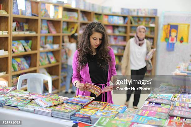 Palestinians read books at a Book Fair that kicked off at Christian Youth Association in Gaza City, on April 28, 2016. The book fair was held to...