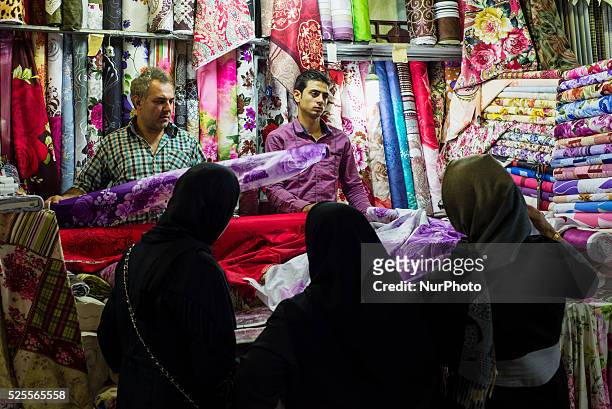 Woman choosing textile at the stall in Grand bazaar in Tehran, Iran