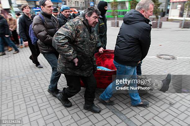 People carry the victim of the sniper fire
