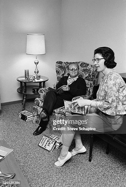 View of American author Truman Capote autographs copies of his non-fiction novel 'In Cold Blood' as he sits with Marie Dewey , Kansas, 1967. Capote...