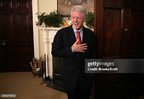 Former President Bill Clinton jokes with reporters about his golf game after he and former President Bush met with President George W. Bush at the...