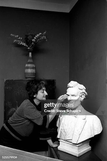 Betty Friedan attends to Abraham Lincoln bust in her home.