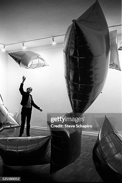 American Pop artist Andy Warhol plays with one of the mylar balloons from his 'Silver Clouds' installation at the Leo Castelli Gallery, New York, New...