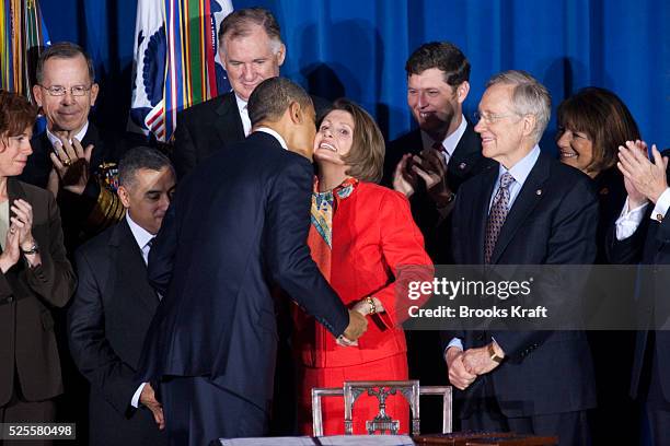 President Barack Obama kisses Speaker of the House Nancy Pelosi before signing the Don't Ask, Don't Tell Repeal Act of 2010 into law at the U.S....