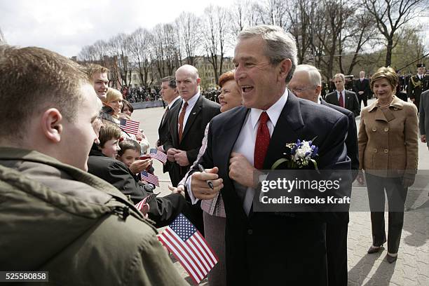 President George W. Bush shakes hands with the crowd with Latvian President Vaira Vike Freiberga,as U.S. First lady Laura Bush looks on, after a...