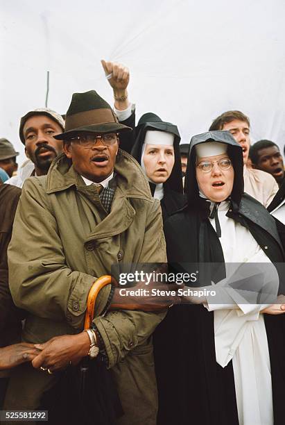 Vivian holding hands with a nun during a rally before beginning the march from Selma to Montgomery. They are marching to protest denial of voting...