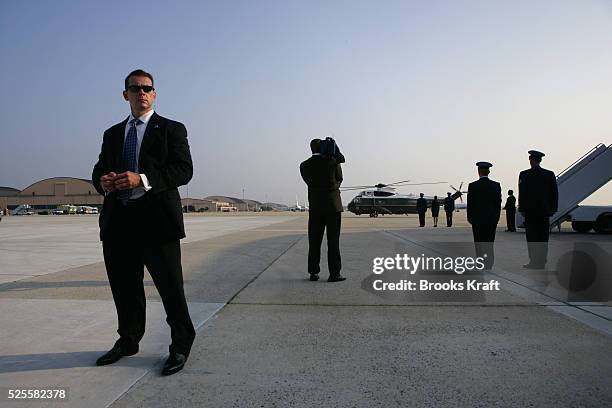 Secret Service agents watch as U.S. President George W. Bush and First Lady Laura Bush arrive at Andrews Air Force Base in Maryland, July 5, 2005.