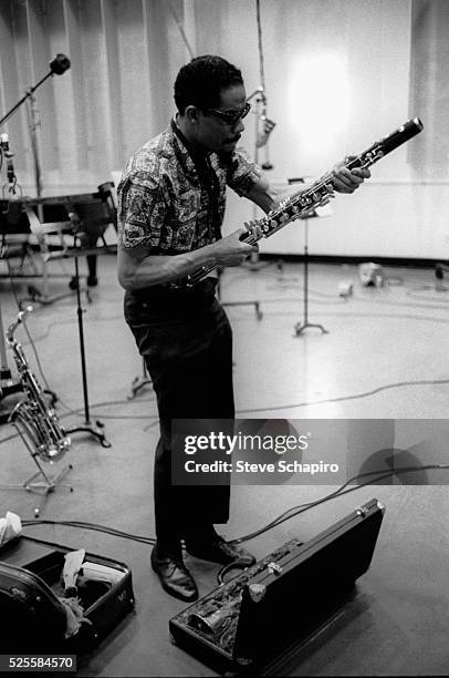 Eric Dolphy assembling a bass clarinet during the recording of George Russell's Ezz-thetics album at Riverside Studios.