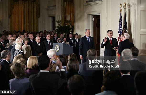 Judge John Roberts, center, is sworn in as the 17th Chief Justice of the United States by Associate Supreme Court Justice John Paul Stevens, right,...